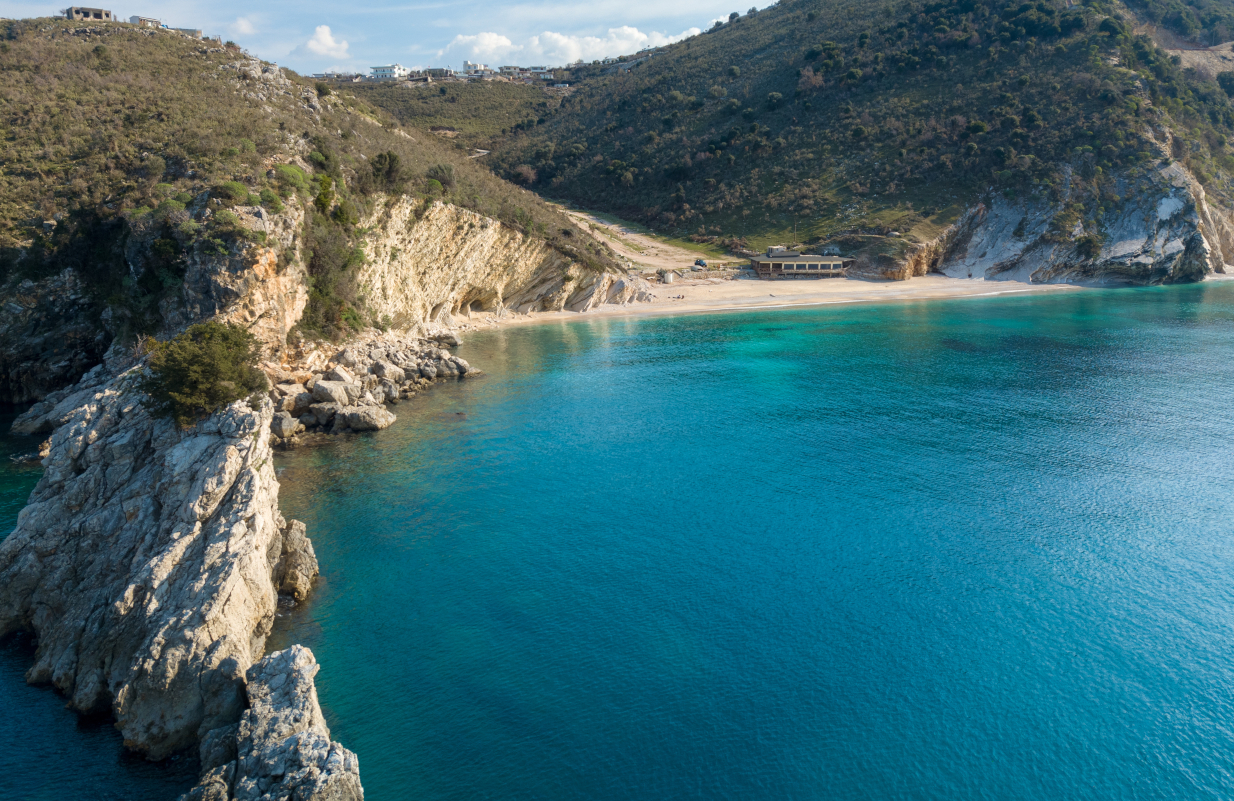 Κι όμως δεν είναι ελληνική: Η παραλία με τα πιο γαλάζια νερά βρίσκεται δίπλα μας - Στη χώρα που πάντα βλέπαμε αφ' υψηλού και τώρα κάνει ρελάνς τουριστικά